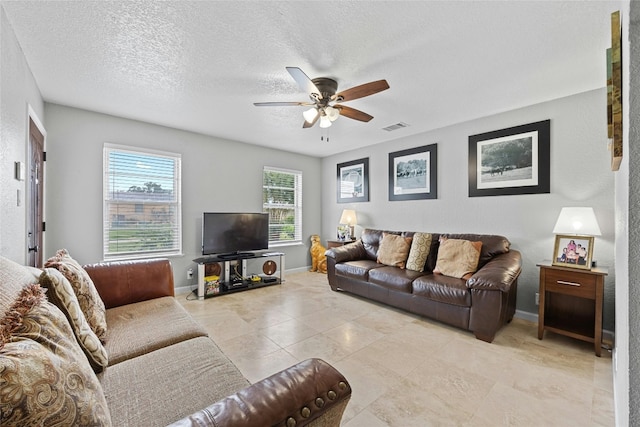 tiled living room featuring a textured ceiling and ceiling fan