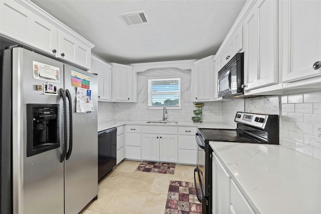 kitchen featuring sink, white cabinets, decorative backsplash, black appliances, and light stone countertops