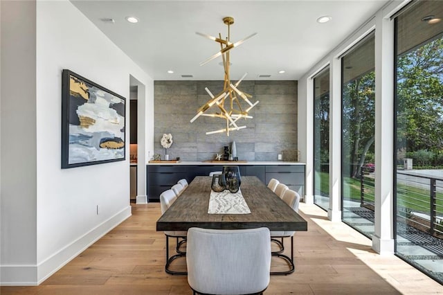 dining area with light wood-style floors, recessed lighting, baseboards, and an inviting chandelier