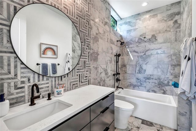 full bathroom featuring tile walls, backsplash, vanity, tiled shower / bath, and toilet