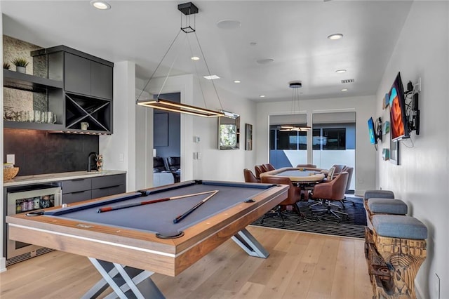 playroom featuring pool table, beverage cooler, wet bar, and light hardwood / wood-style flooring