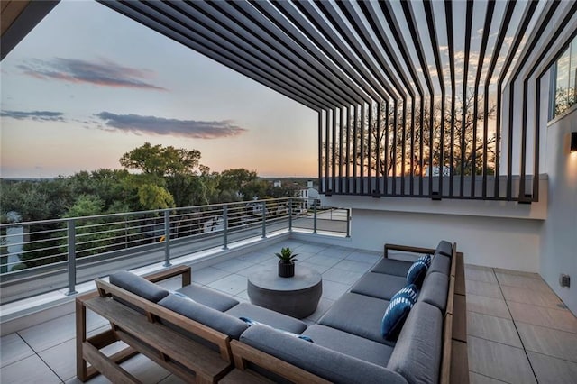 patio terrace at dusk with a balcony and an outdoor hangout area