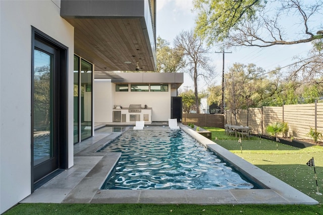 view of pool with a fenced backyard and an outdoor kitchen