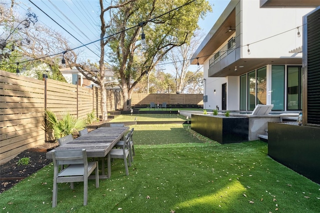 view of yard with a balcony and a fenced backyard