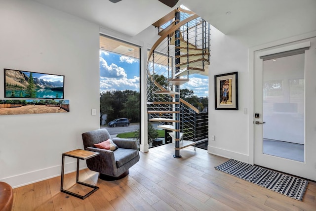 entryway with hardwood / wood-style flooring, stairs, expansive windows, and baseboards