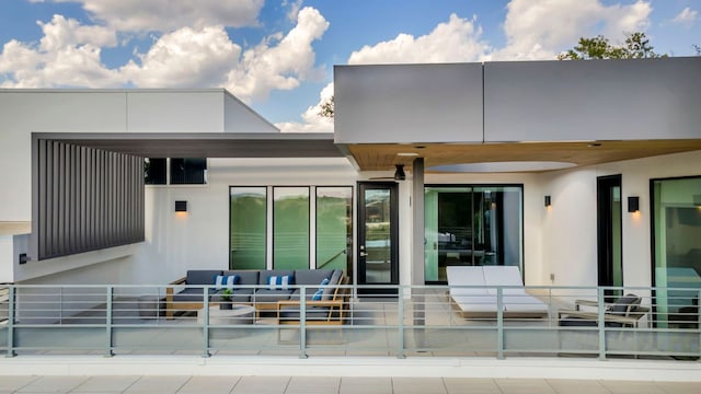 rear view of property featuring a patio area, an outdoor living space, and stucco siding