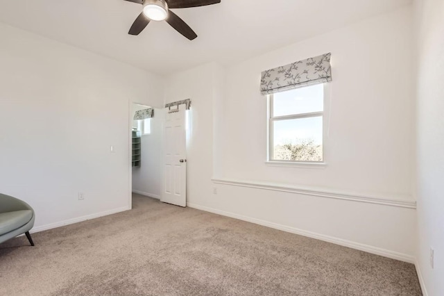 empty room featuring light colored carpet and ceiling fan