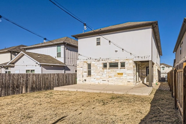 205 Audie Murphy Cir, Leander, TX 78641 - back of house featuring a patio area, a fenced backyard, stone siding, and central AC unit