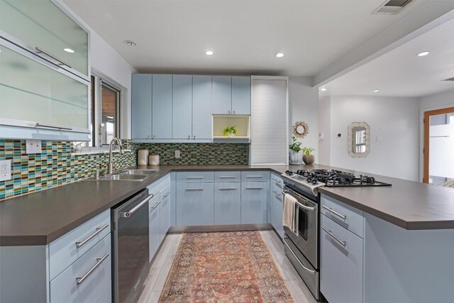 3601 Marcae Ct, Austin, TX 78704 - kitchen with appliances with stainless steel finishes, dark countertops, a sink, a peninsula, and tasteful backsplash