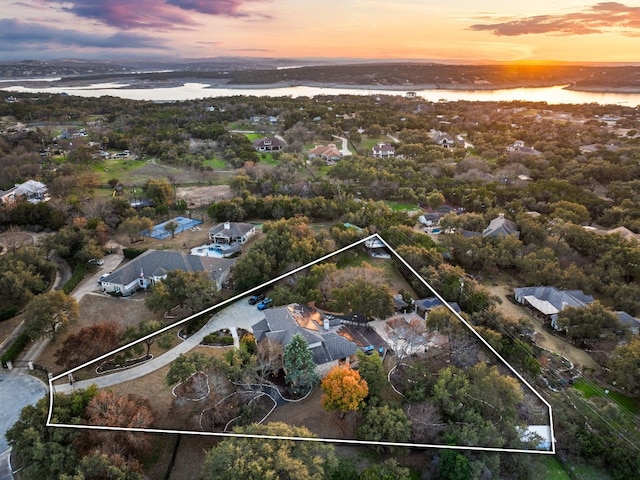 aerial view at dusk featuring a water view