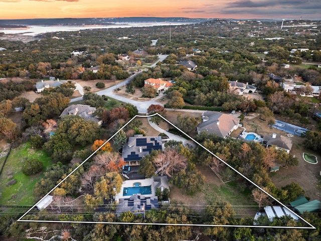 aerial view at dusk featuring a water view