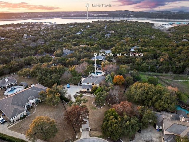 aerial view at dusk featuring a water view