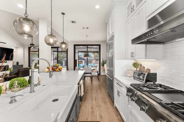 kitchen featuring hanging light fixtures, white cabinetry, and sink