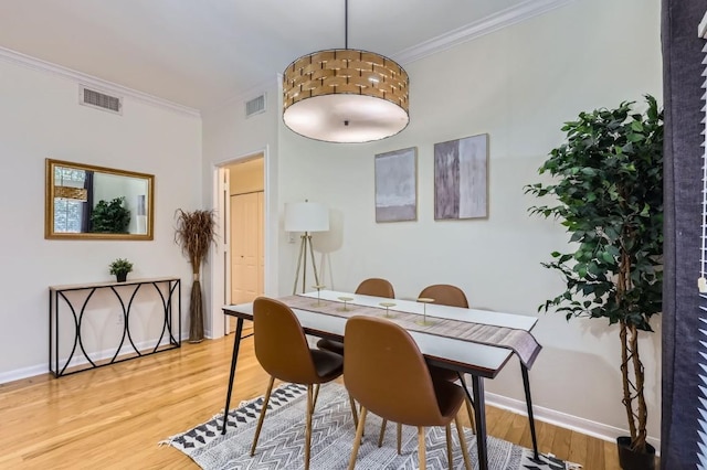 dining area with wood-type flooring and ornamental molding