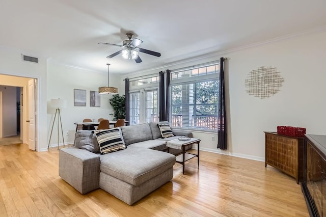 living room with crown molding, ceiling fan, and light hardwood / wood-style flooring