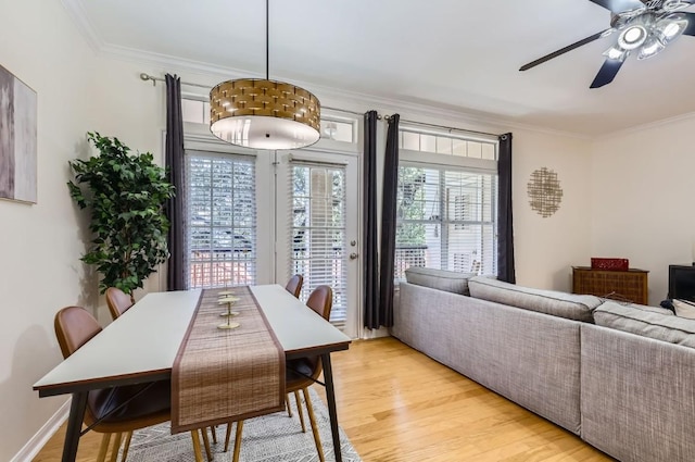 dining room featuring ceiling fan, light hardwood / wood-style flooring, ornamental molding, and a healthy amount of sunlight