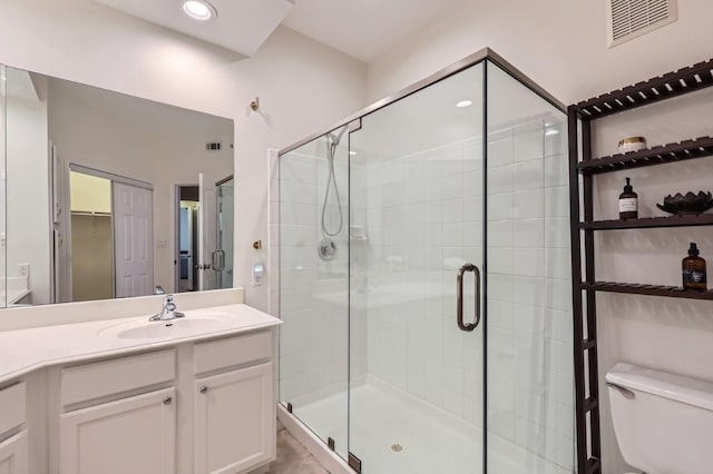 bathroom featuring an enclosed shower, vanity, and toilet