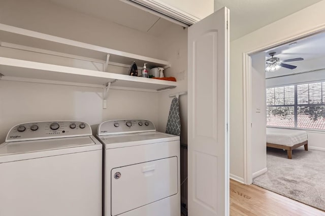 laundry room with light colored carpet, washing machine and dryer, and ceiling fan