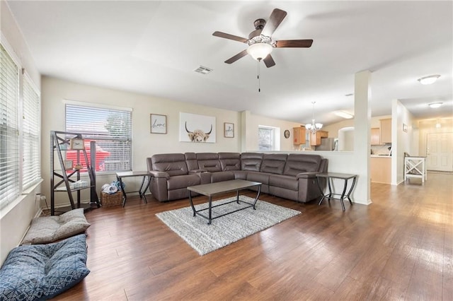 living room with vaulted ceiling, ceiling fan with notable chandelier, and dark hardwood / wood-style flooring