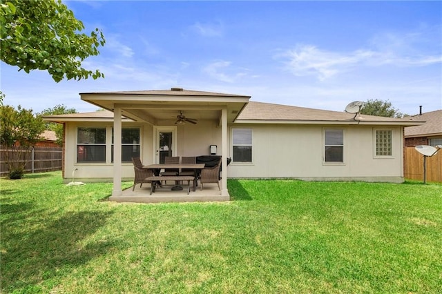 rear view of property with ceiling fan, a yard, and a patio area