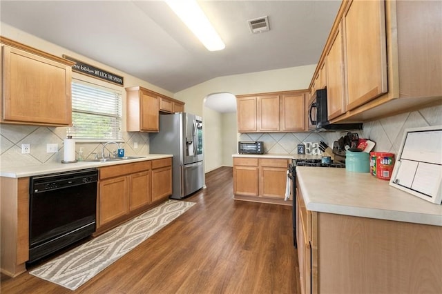 kitchen with lofted ceiling, sink, backsplash, dark hardwood / wood-style flooring, and black appliances