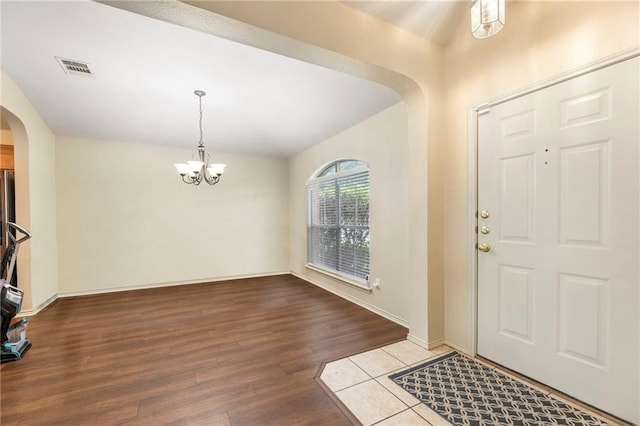 foyer entrance with an inviting chandelier and hardwood / wood-style floors