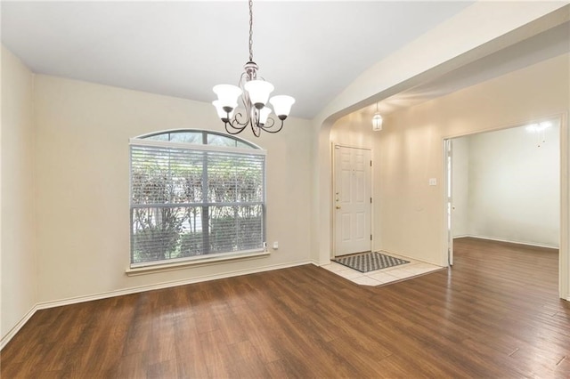 entrance foyer with hardwood / wood-style flooring, lofted ceiling, and a notable chandelier