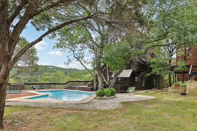 view of swimming pool featuring a mountain view, a lawn, and a patio