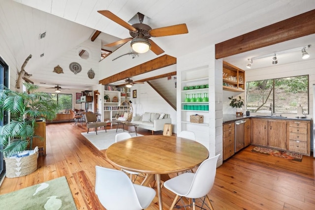 dining room with beamed ceiling, a healthy amount of sunlight, and light hardwood / wood-style floors