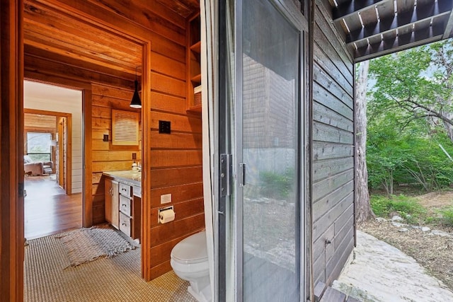 bathroom with wooden walls and toilet