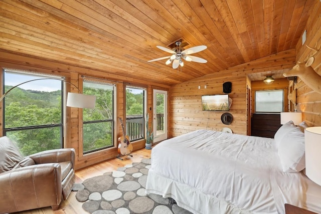 bedroom featuring vaulted ceiling, wooden walls, access to exterior, wood ceiling, and light hardwood / wood-style floors