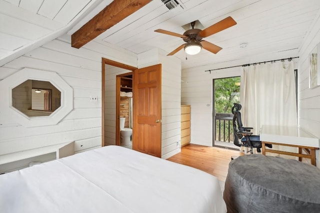 bedroom with hardwood / wood-style floors, wood walls, access to exterior, ceiling fan, and beam ceiling