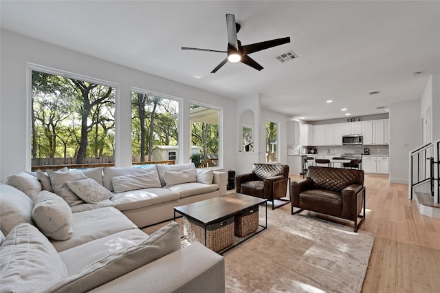 living room with ceiling fan and light hardwood / wood-style floors