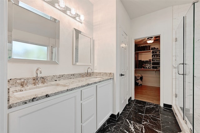 bathroom featuring a shower with door, vanity, and ceiling fan