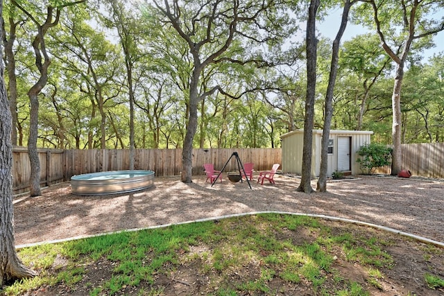 view of yard with a hot tub and a storage unit