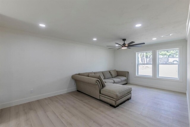 living room featuring crown molding, ceiling fan, and light wood-type flooring