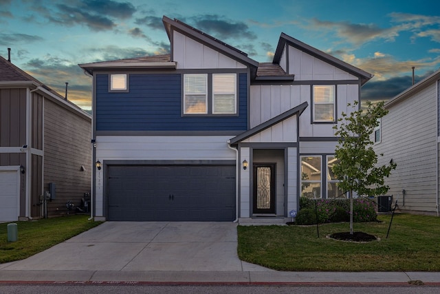 view of front of home featuring a garage, central AC unit, and a lawn