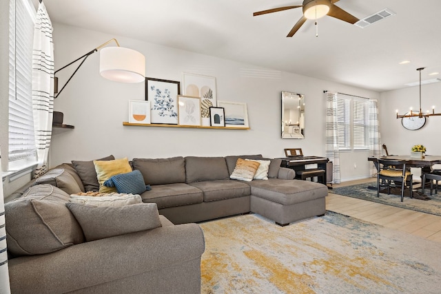 living room featuring hardwood / wood-style floors and ceiling fan with notable chandelier