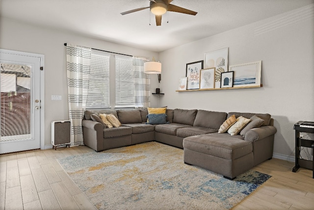 living room featuring wood-type flooring and ceiling fan