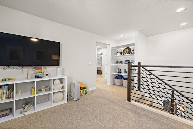 playroom with light colored carpet and a textured ceiling