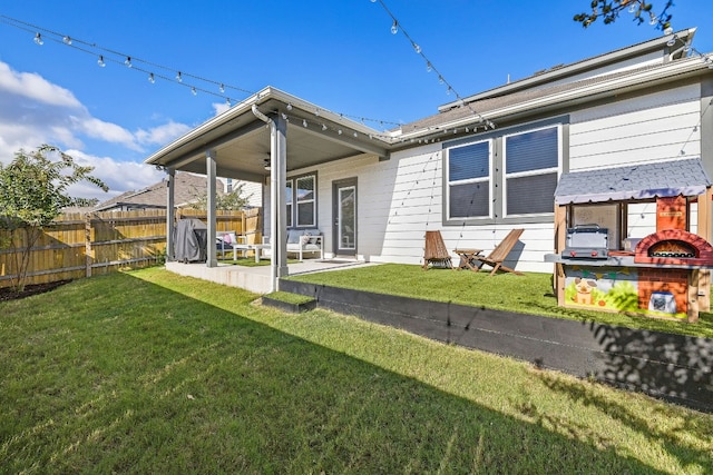 rear view of property with a lawn and a patio area