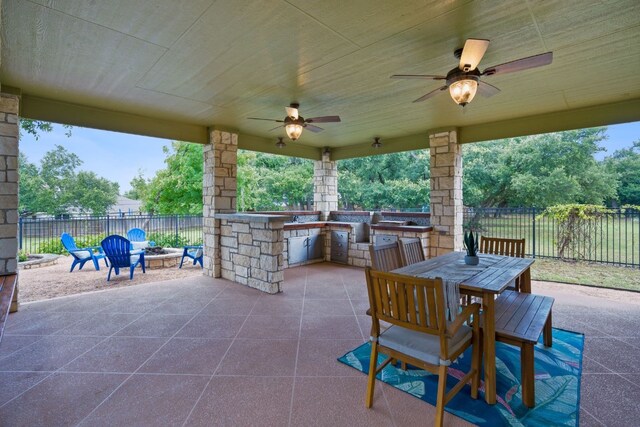 139 Jackrabbit Run, Round Rock, TX 78664 - view of patio with an outdoor fire pit, an outdoor kitchen, a ceiling fan, and outdoor dining space