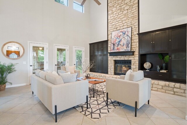 139 Jackrabbit Run, Round Rock, TX 78664 - living room featuring a towering ceiling, a fireplace, light tile patterned floors, and baseboards