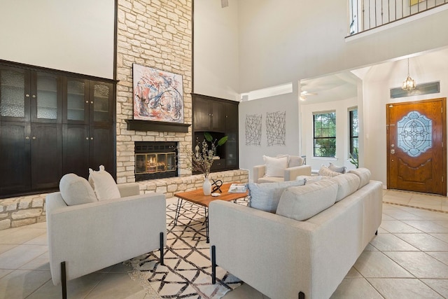 tiled living room with a towering ceiling and a fireplace