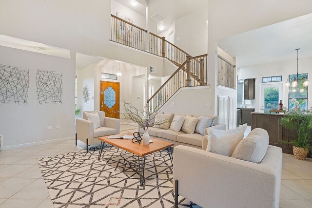139 Jackrabbit Run, Round Rock, TX 78664 - living room with a towering ceiling, tile patterned flooring, stairs, and a chandelier