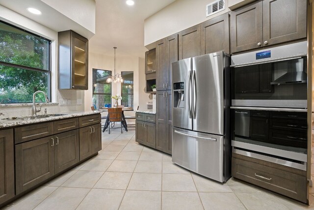 139 Jackrabbit Run, Round Rock, TX 78664 - kitchen with appliances with stainless steel finishes, a sink, light tile patterned flooring, dark brown cabinets, and a chandelier