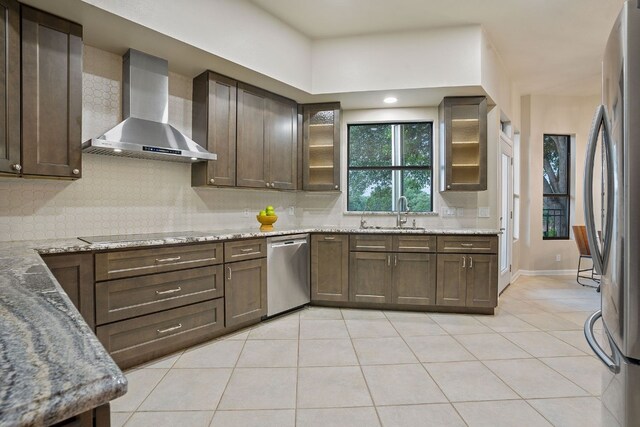 139 Jackrabbit Run, Round Rock, TX 78664 - kitchen with wall chimney range hood, appliances with stainless steel finishes, a sink, light tile patterned flooring, and backsplash