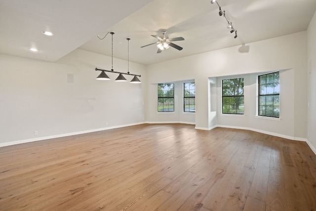 unfurnished room with rail lighting, ceiling fan, and light wood-type flooring