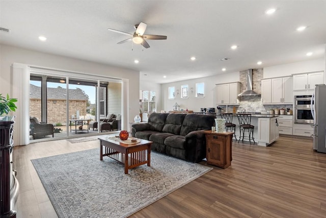 living room featuring wood-type flooring and ceiling fan