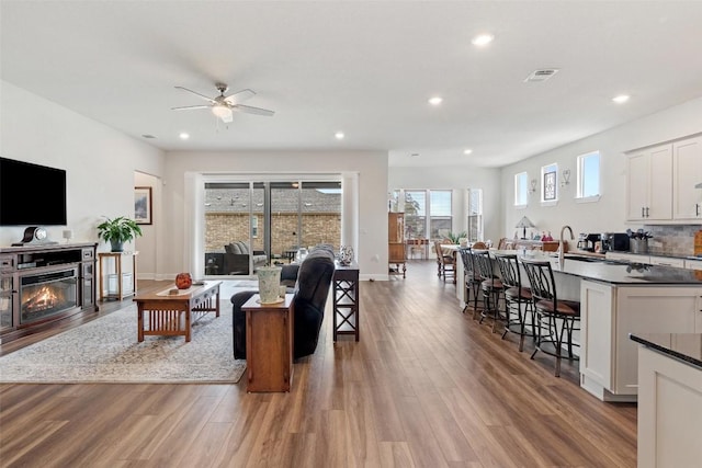 living room with ceiling fan and light wood-type flooring